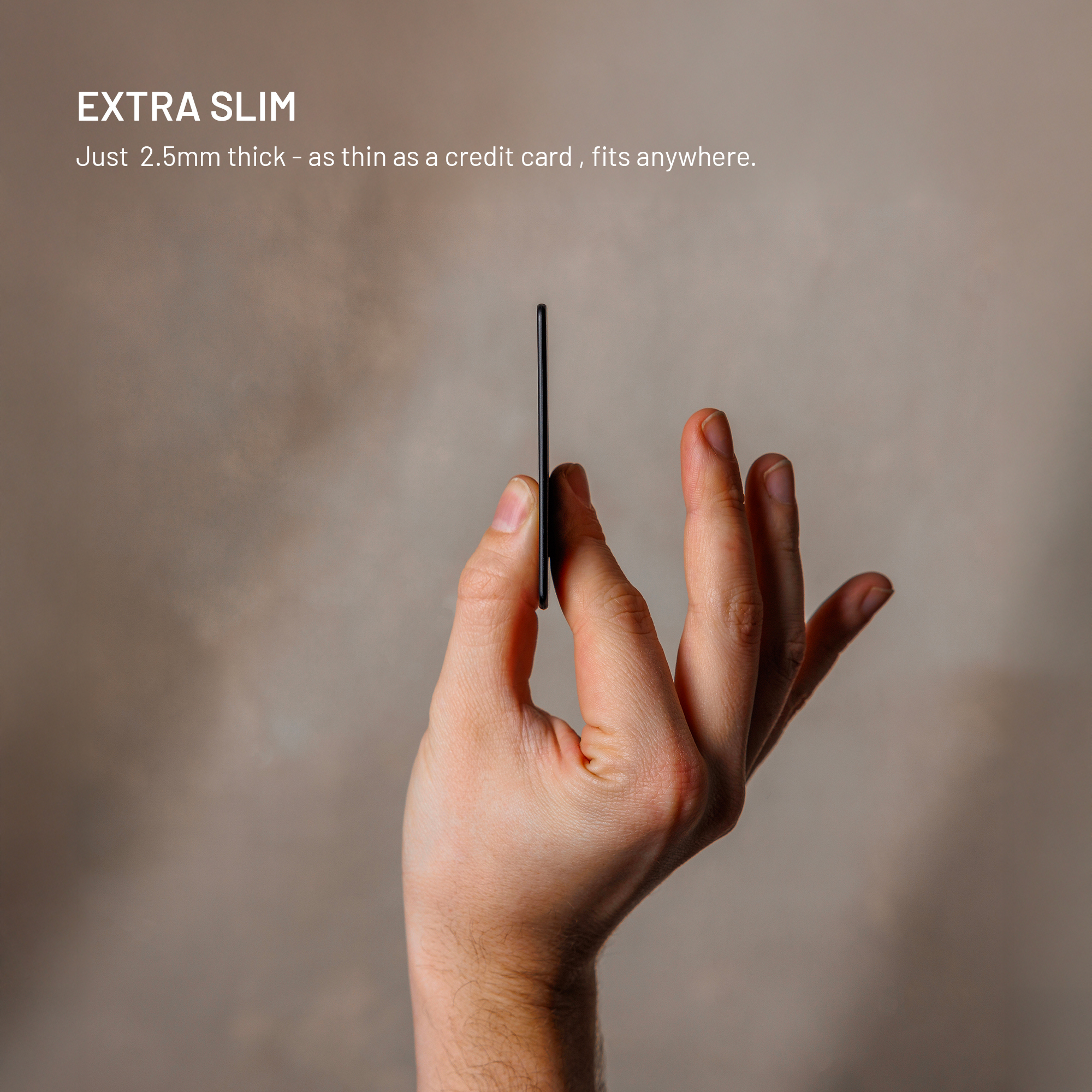 Eine Hand hält eine extrem schmale, schwarze Karte in einem neutralen Raum.