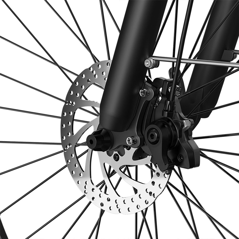 Primer plano de un freno de disco de bicicleta con rotor plateado, pinza negra y radios de rueda.