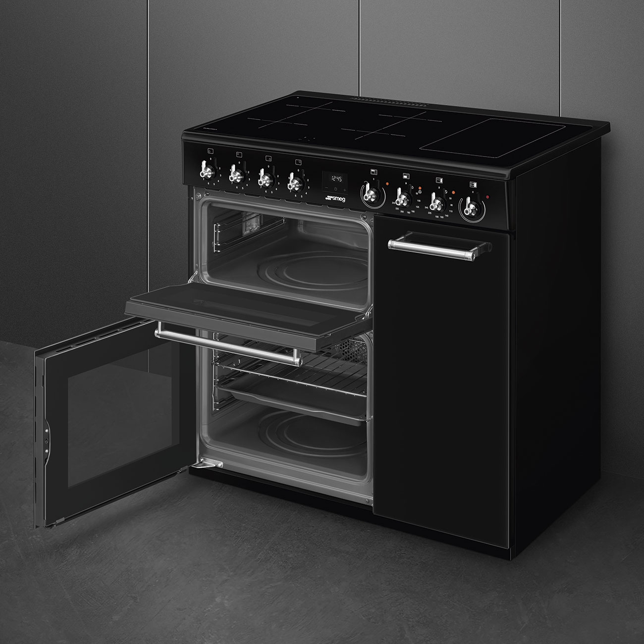 Un forno doppio nero con piano cottura a induzione e porte aperte, su sfondo grigio scuro.