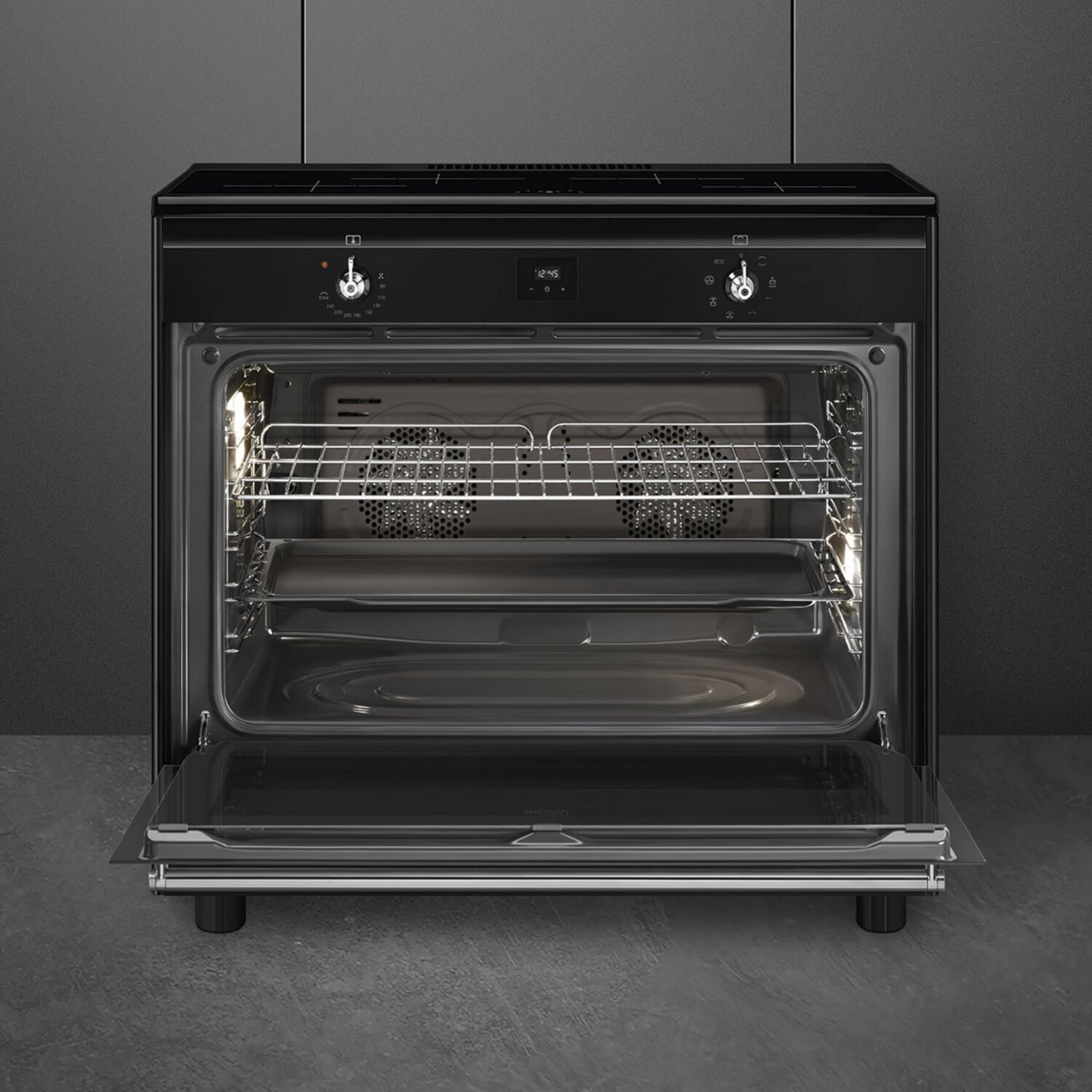 Un forno elettrico nero con la porta aperta, ripiani in metallo, una teglia e luci interne accese.