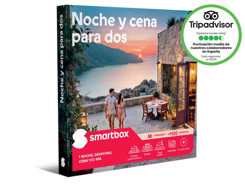 Una caja Smartbox de 'Noche y cena para dos' con una pareja caminando en una terraza con vistas al mar al atardecer.