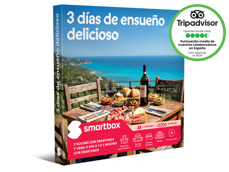 Caja de regalo Smartbox con una mesa de madera puesta junto al mar azul y texto en español.