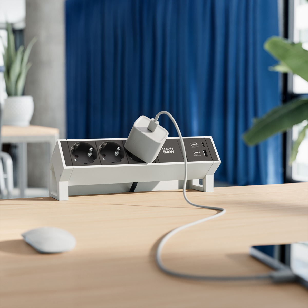Une multiprise blanche sur un bureau en bois, un câble de chargement branché mène à un smartphone.