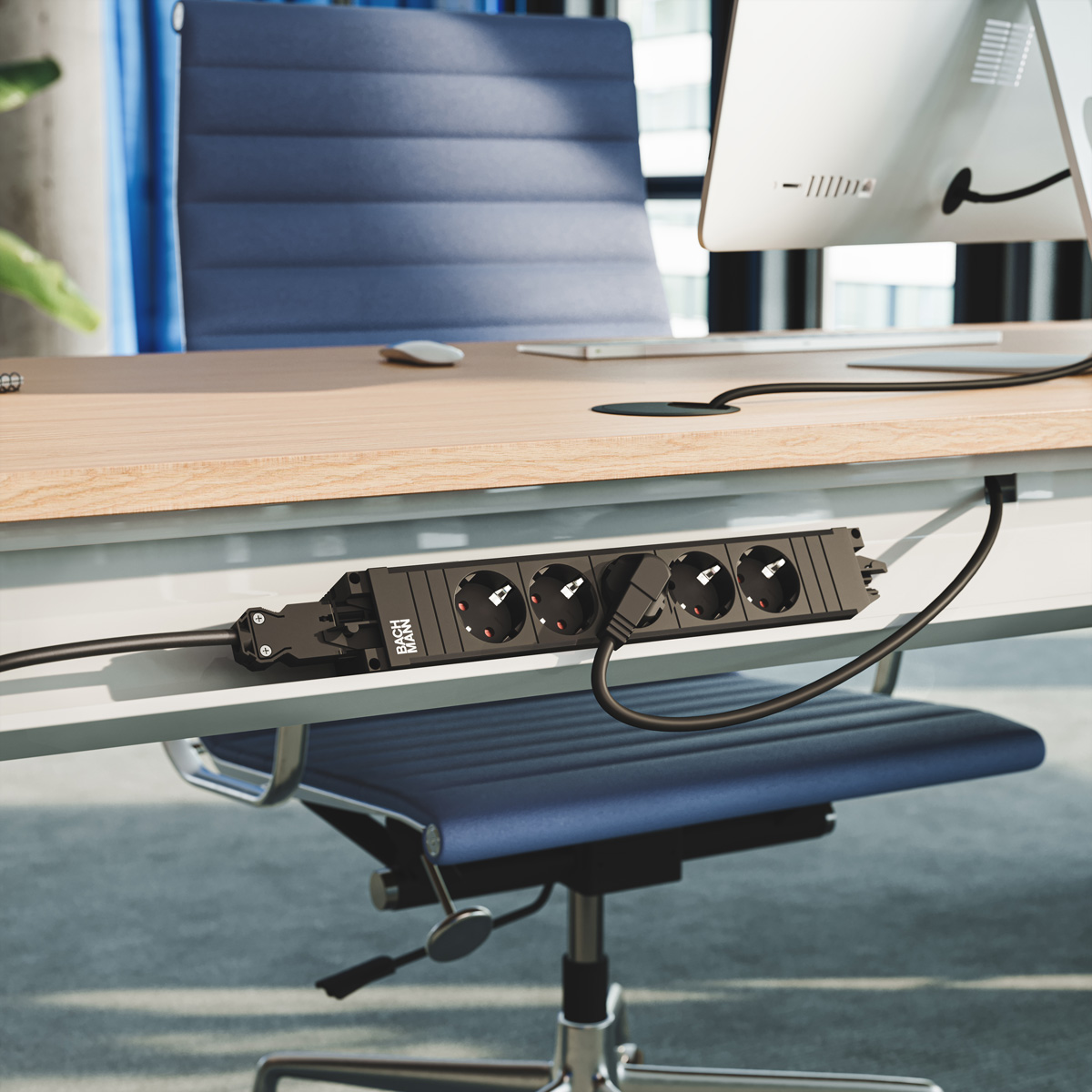 Eine schwarze Steckdosenleiste ist unter einem modernen Bürotisch mit einem blauen Stuhl und Computer montiert.