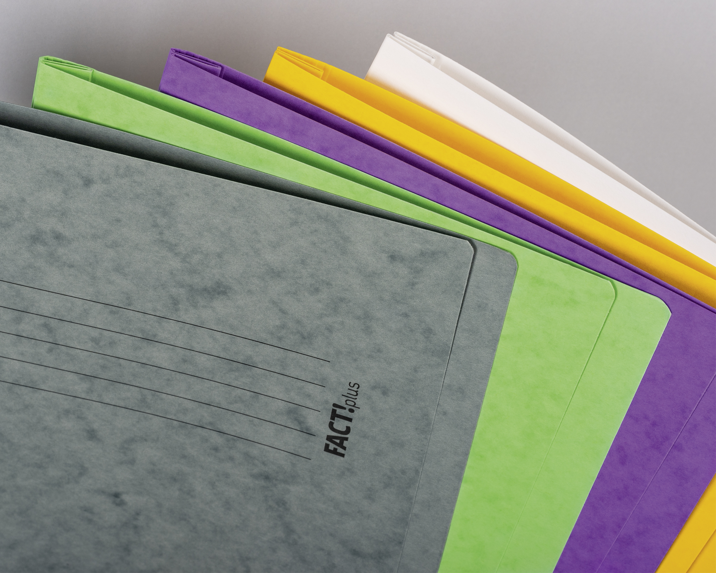 Mehrere bunte Papierordner in Grau, Grün, Lila, Gelb und Weiß, leicht versetzt auf grauem Hintergrund.