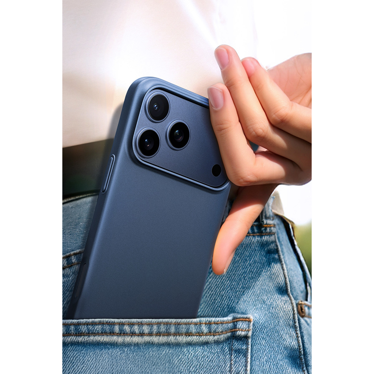 Bir kişi mavi kot pantolonunun arka cebine mavi bir akıllı telefon koyuyor.
