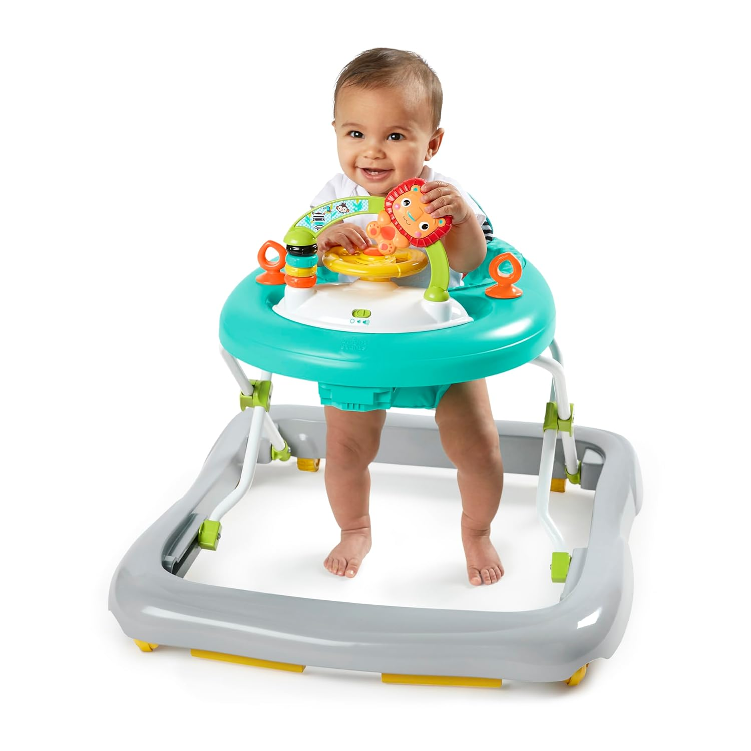 Un bambino sorridente si trova in un girello turchese e bianco con giocattoli colorati su sfondo bianco.