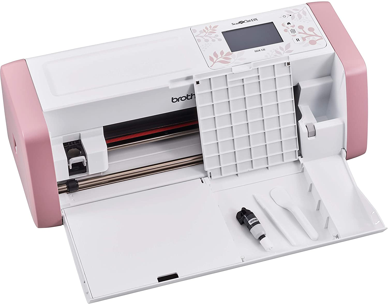 Ein weiß-rosa Brother ScanNCut DX Schneideplotter mit offenem Z収納fach und Werkzeugen auf der Vorderseite.