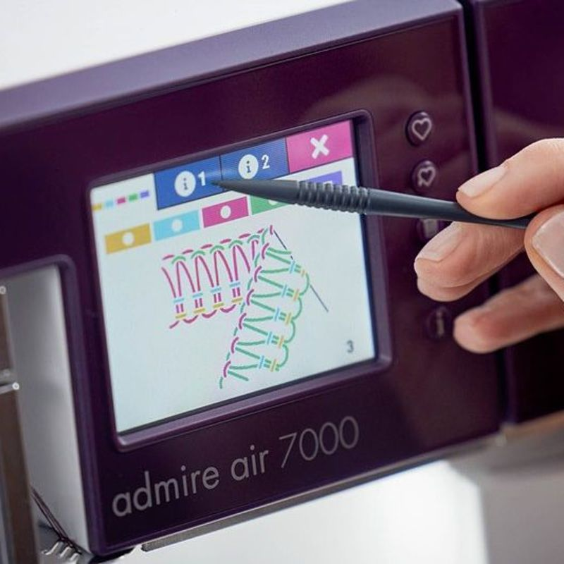 Una mano usa un lápiz óptico para seleccionar un patrón de costura en la pantalla táctil morada.
