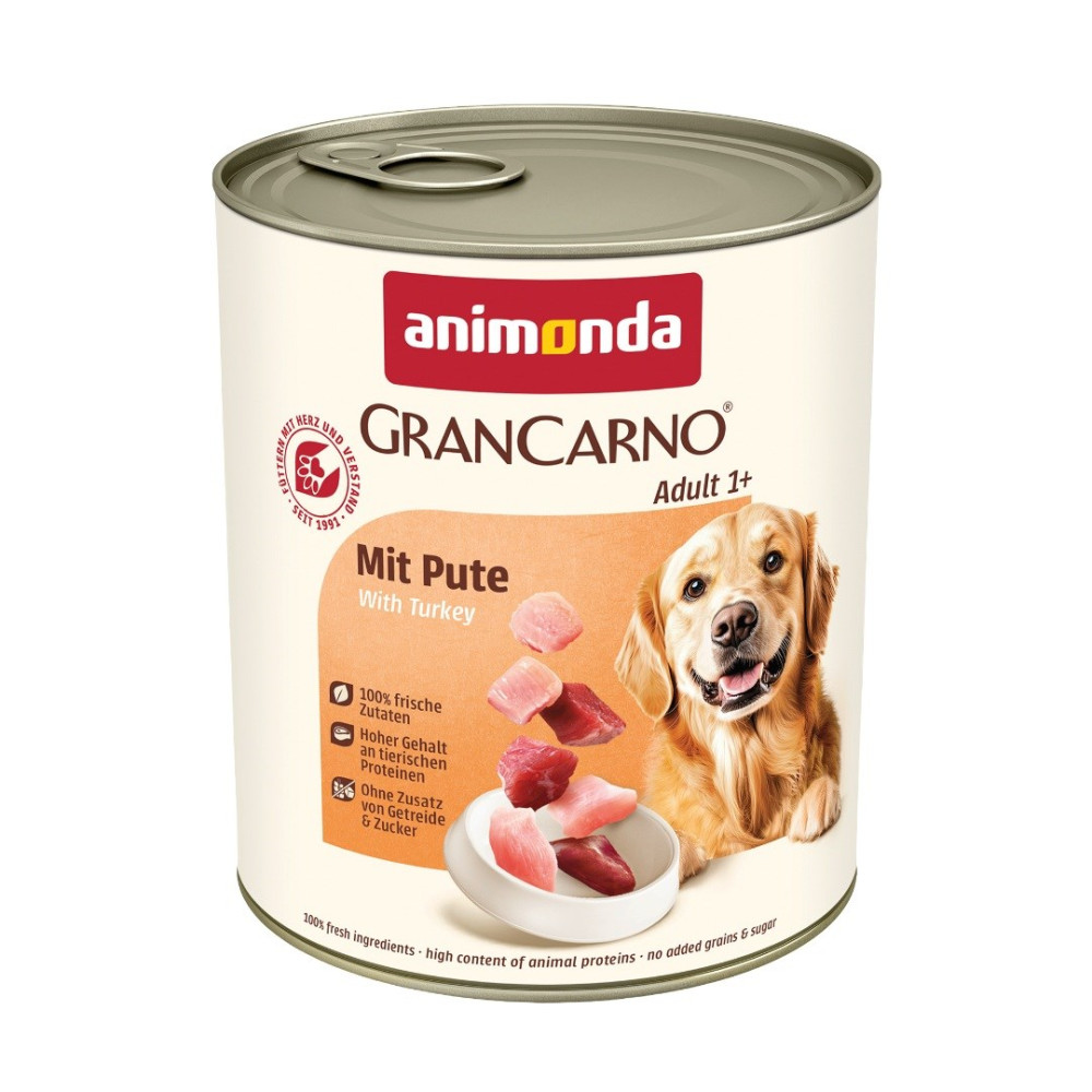 Puszka karma dla psa Animonda GranCarno Adult indyk z golden retrieverem i kawałkami mięsa na białym tle.
