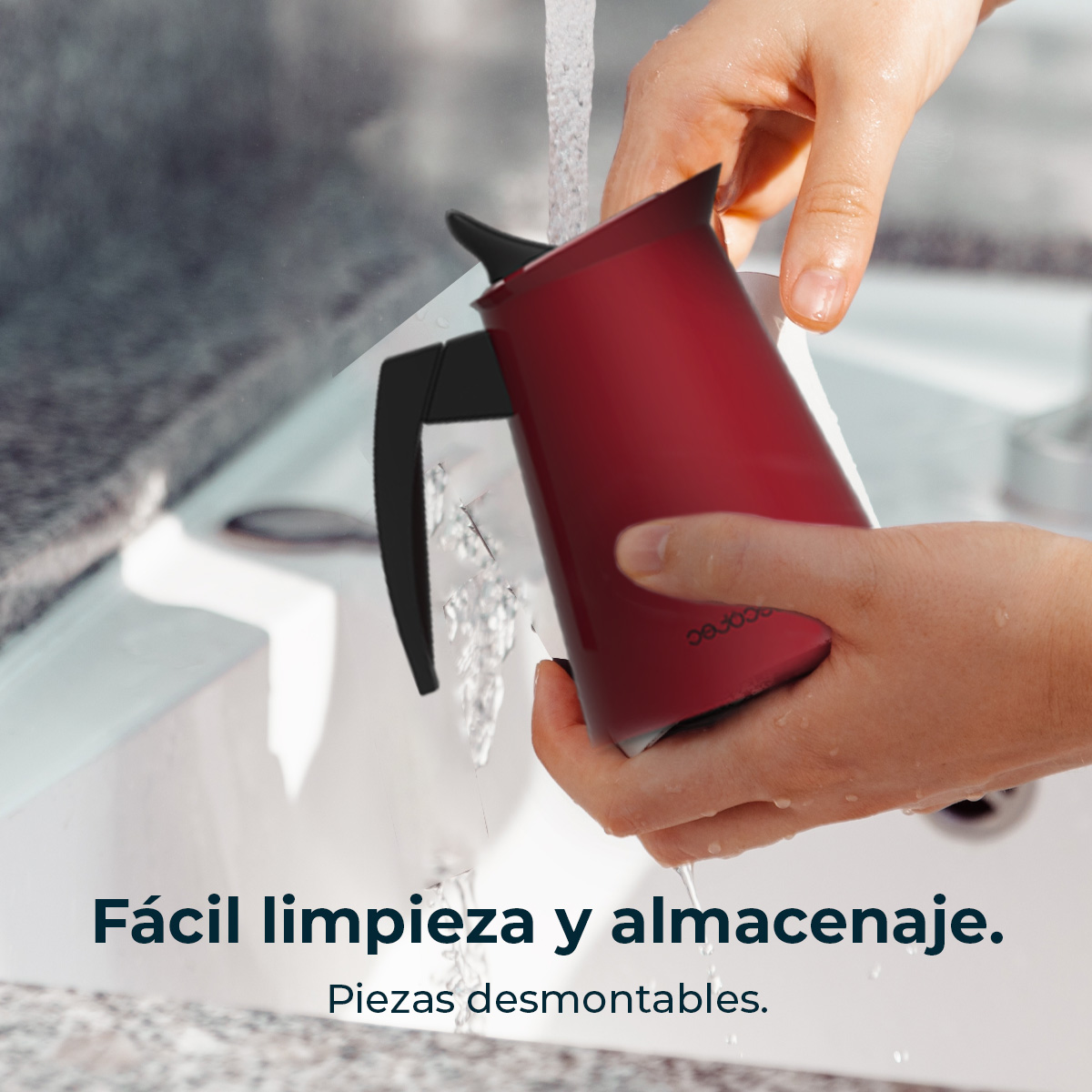 Manos lavando una cafetera roja bajo el grifo en el lavabo.