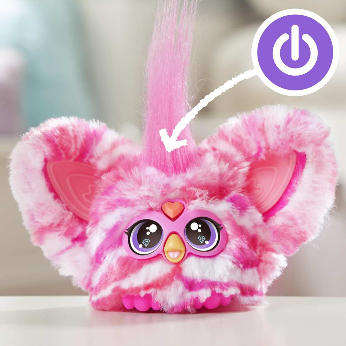 Un juguete peludo rosa y blanco con ojos grandes, forma de corazón y un icono de encendido morado.
