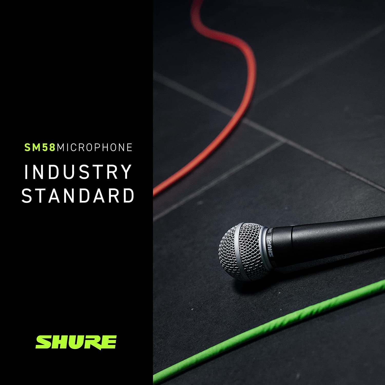 Ein Shure SM58 Mikrofon liegt auf einem dunklen Boden neben roten und grünen Kabeln.