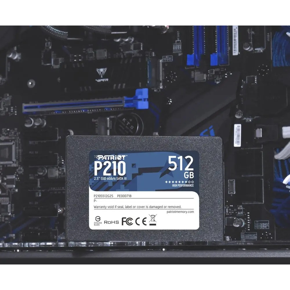 A Patriot P210 512GB SSD mounted inside a computer case above a black motherboard.