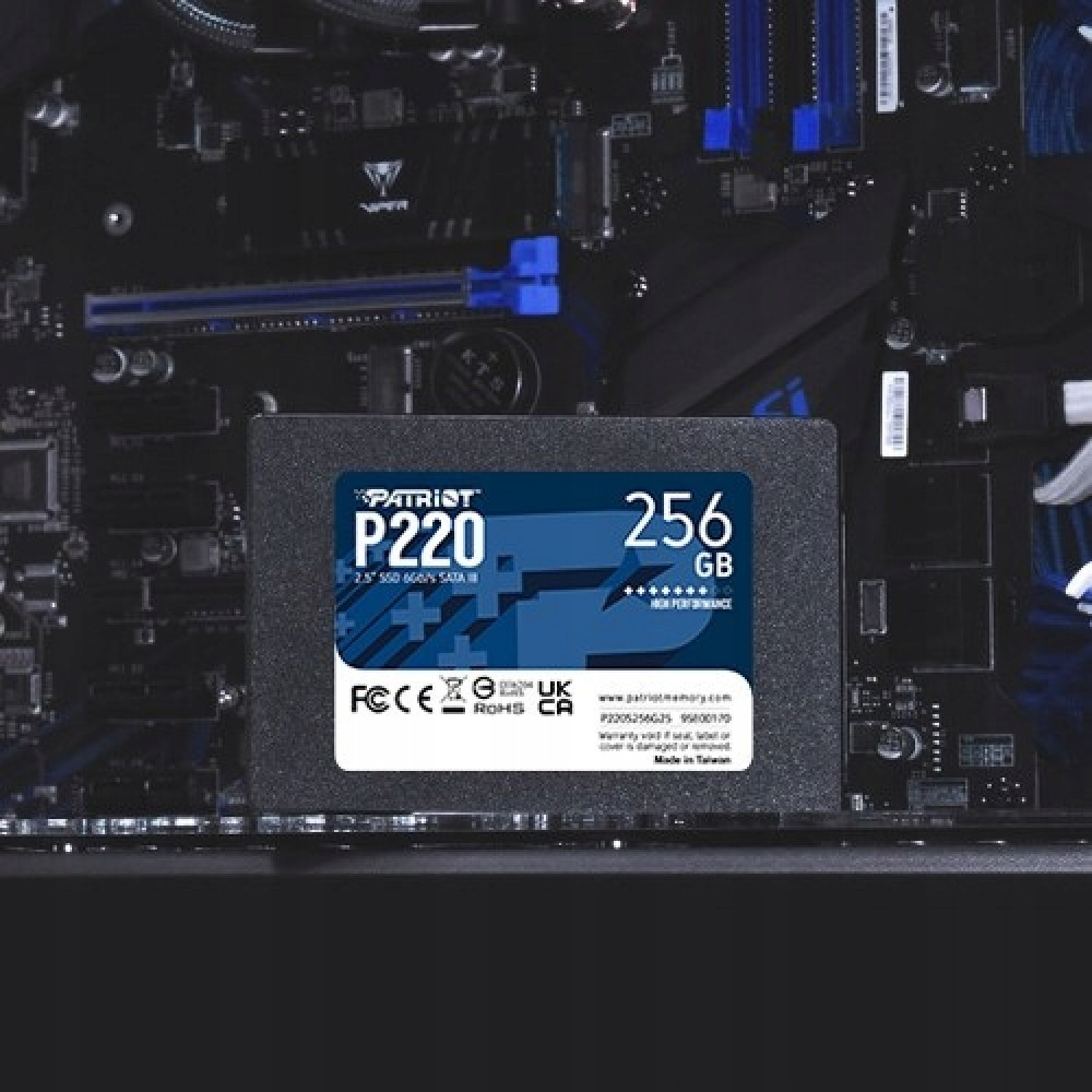Dysk SSD Patriot P220 256 GB jest zamontowany na ciemnej płycie głównej komputera z niebieskimi akcentami.