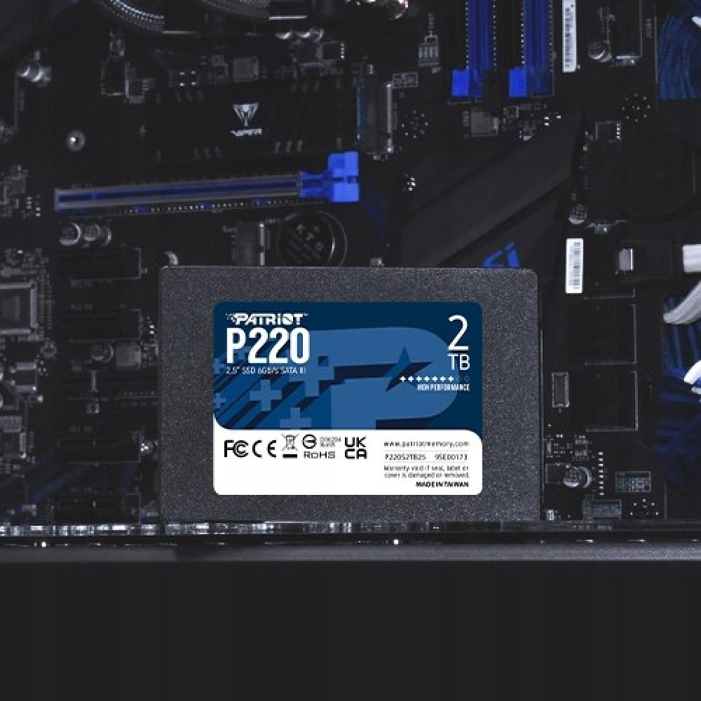 Ein Patriot P220 2TB SSD liegt auf einem schwarzen Computer-Motherboard mit blauen Akzenten.