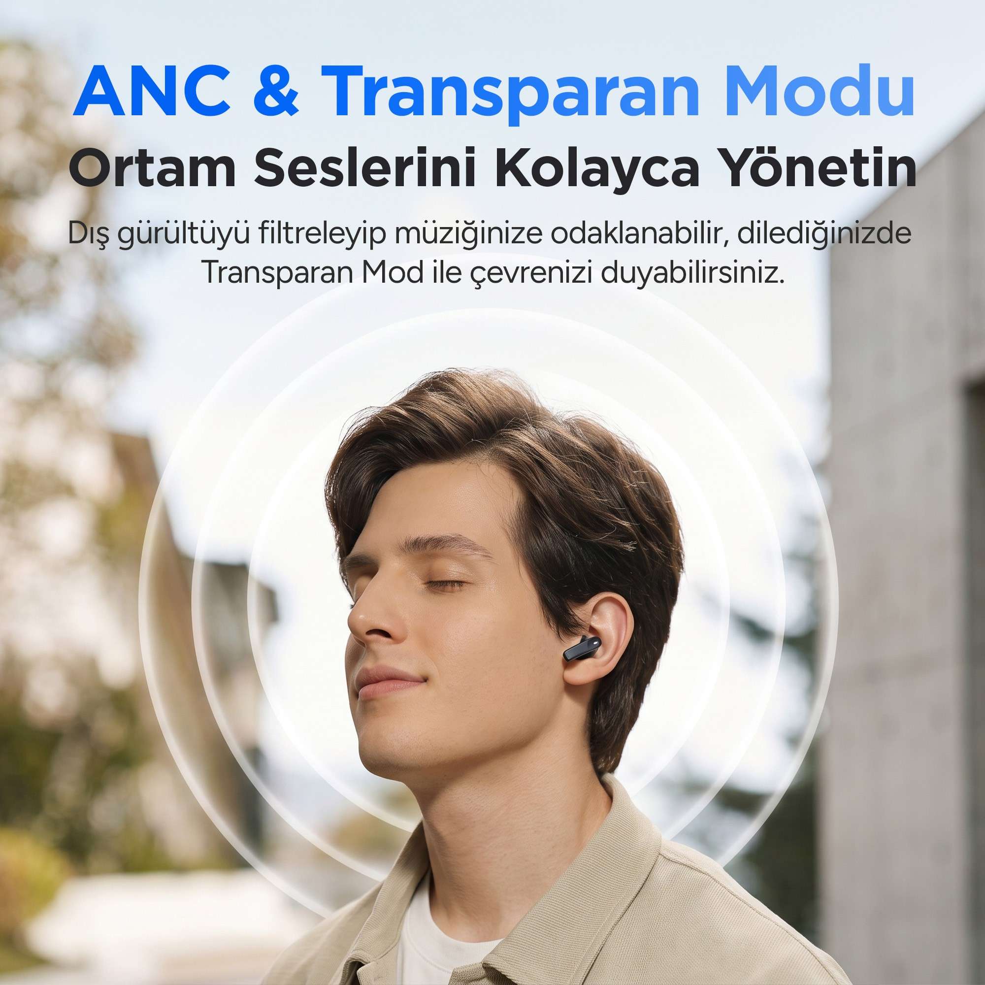 Bulanık bir arka plan önünde siyah kulak içi kulaklık takan, gözleri kapalı genç bir adam.