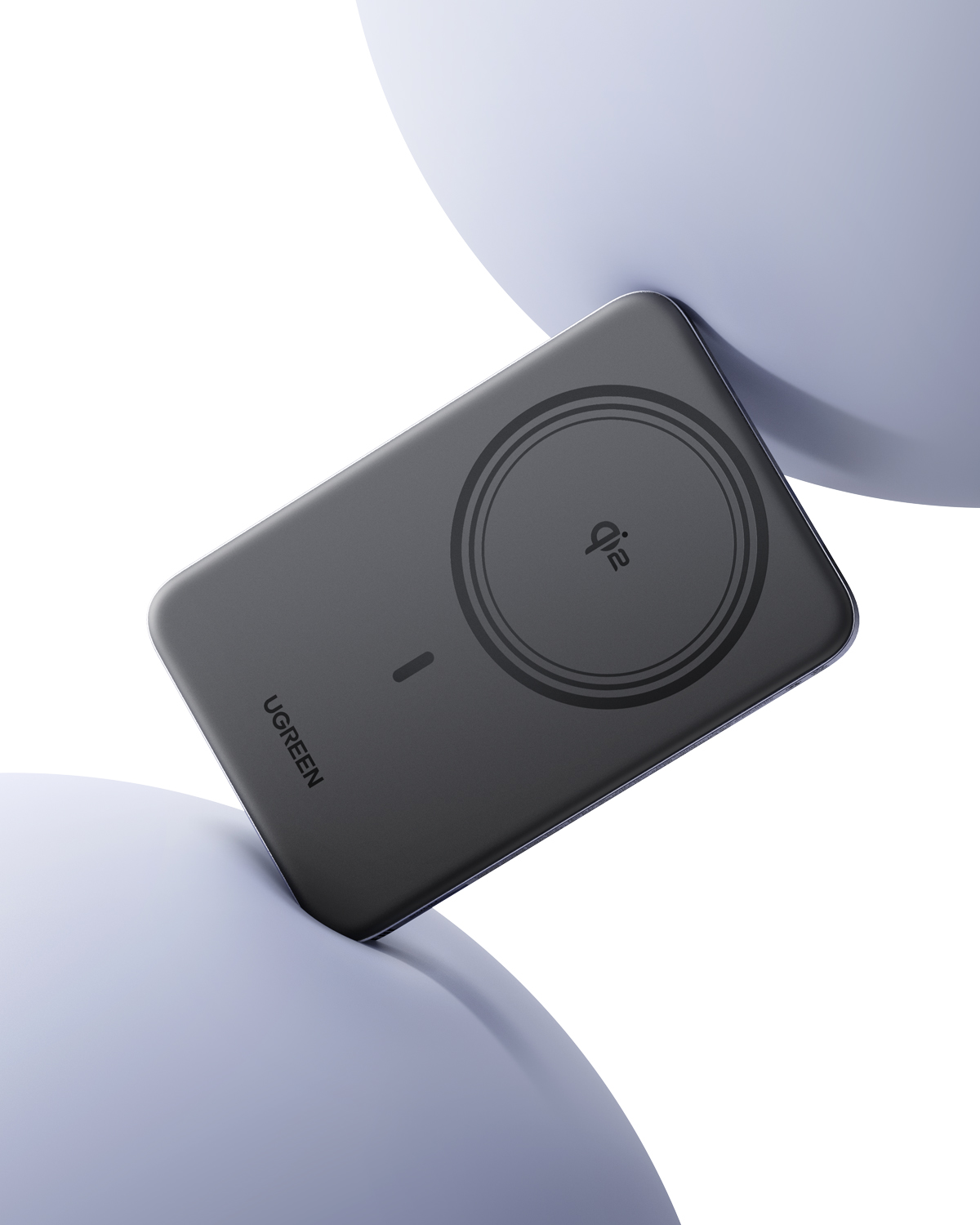 Szary powerbank Ugreen z logo Qi2 jest utrzymywany przez dwie jasne kule na białym tle.