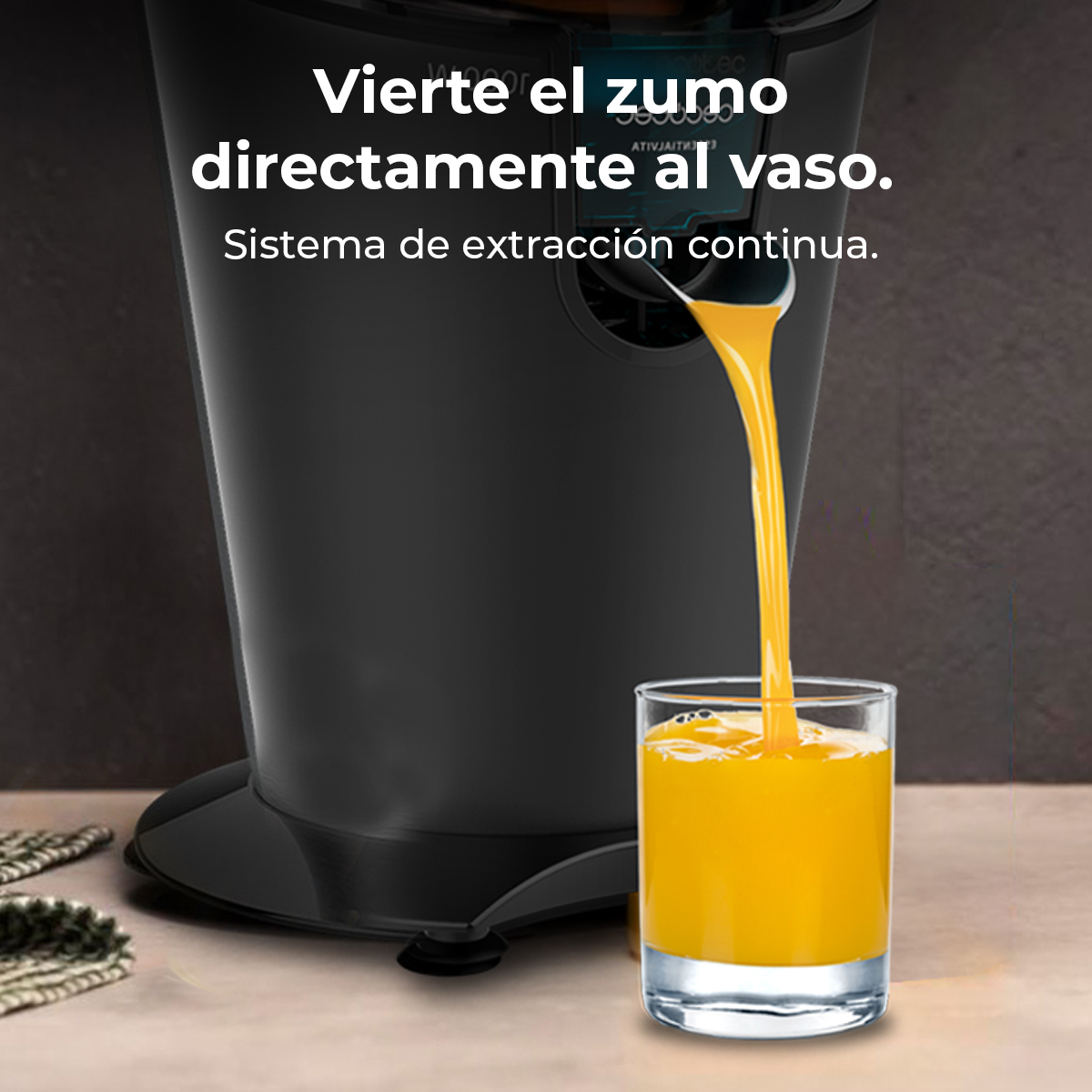 Zumo de naranja fresco vertido desde una licuadora negra en un vaso sobre una encimera de madera.