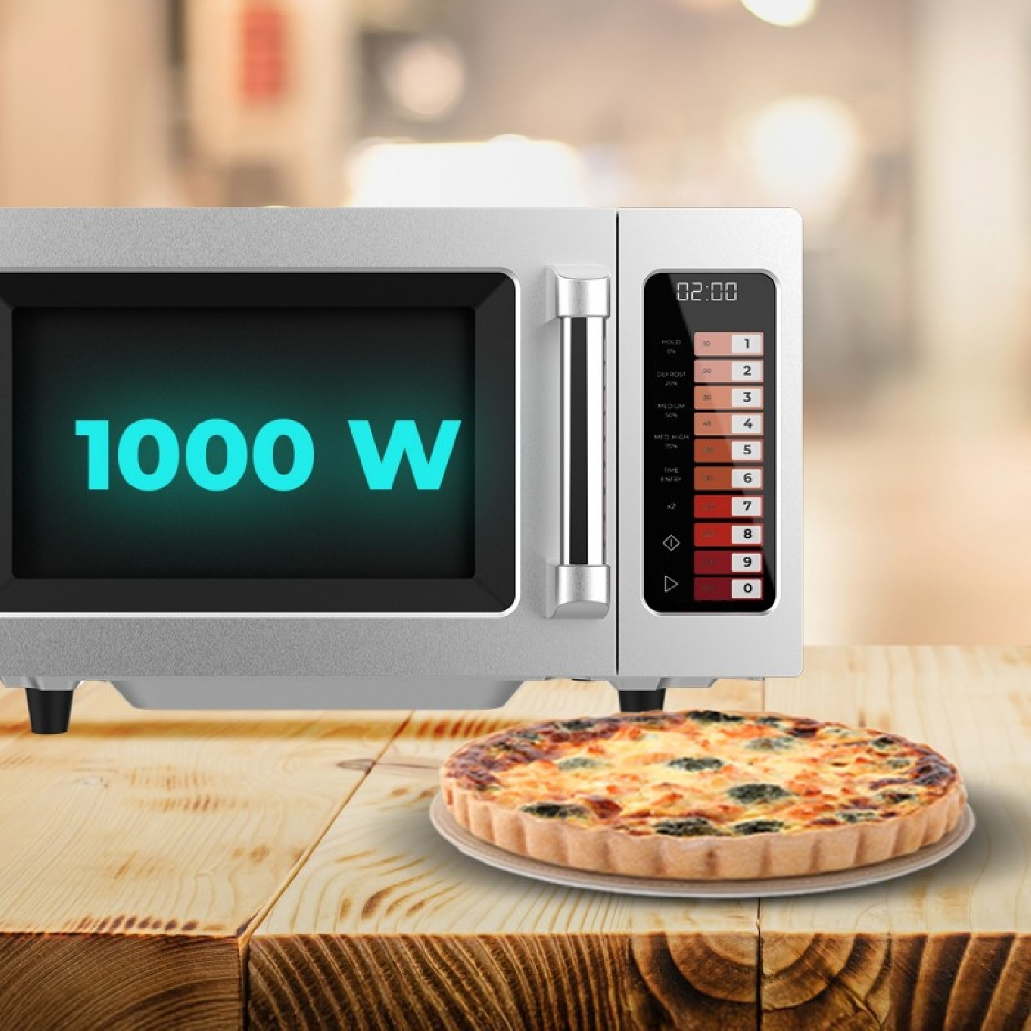 Un microondas plateado de 1000W sobre una mesa de madera al lado de un quiche en una cocina borrosa.