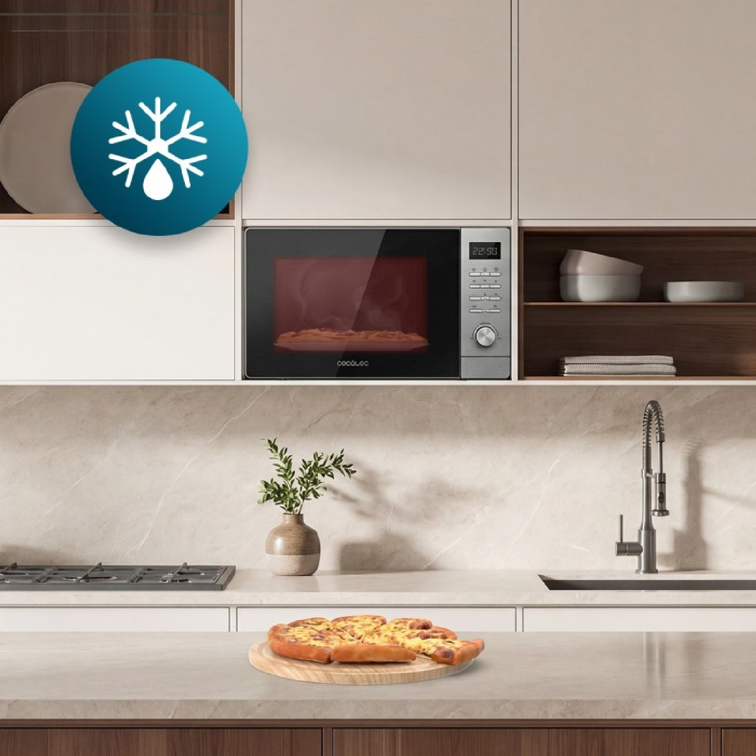 Cocina moderna con microondas, fregadero, estufa y pizza fresca en tabla de madera en primer plano.