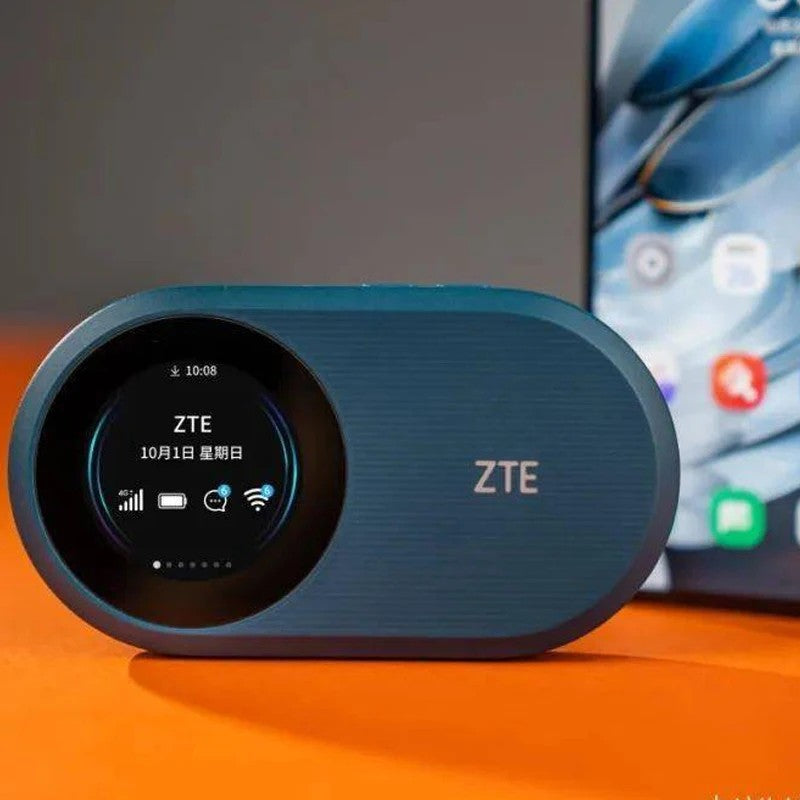 Niebieski router Wi-Fi ZTE z okrągłym wyświetlaczem stoi przed smartfonem na pomarańczowej powierzchni.