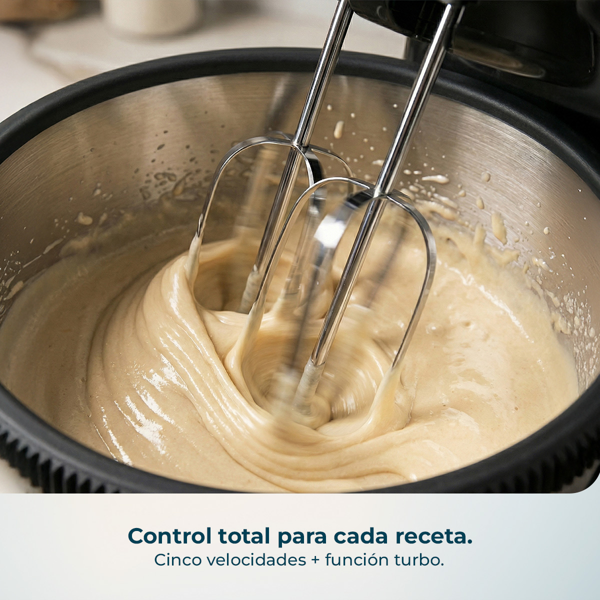 Una batidora eléctrica mezcla masa dentro de un bol de acero inoxidable.