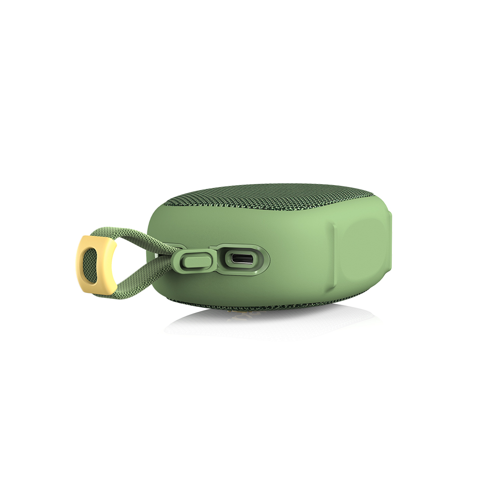 Zielony, kompaktowy głośnik bluetooth z paskiem do przenoszenia i otwartym portem ładowania na białym tle.