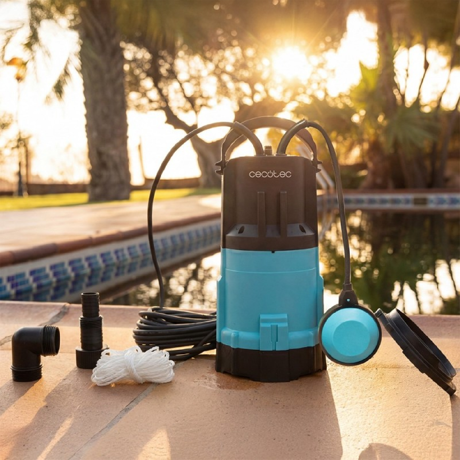 Bomba de agua azul y negra Cecotec con accesorios junto a una piscina.