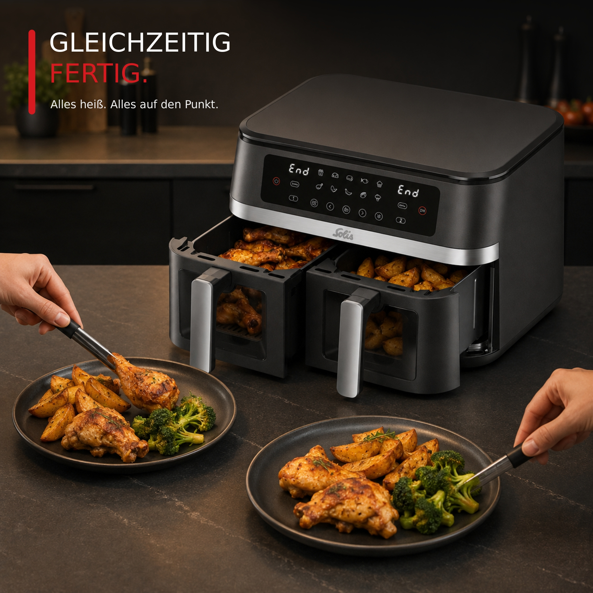 Eine schwarze Heißluftfritteuse mit zwei Fächern und servierten Tellern mit Hähnchen und Brokkoli.