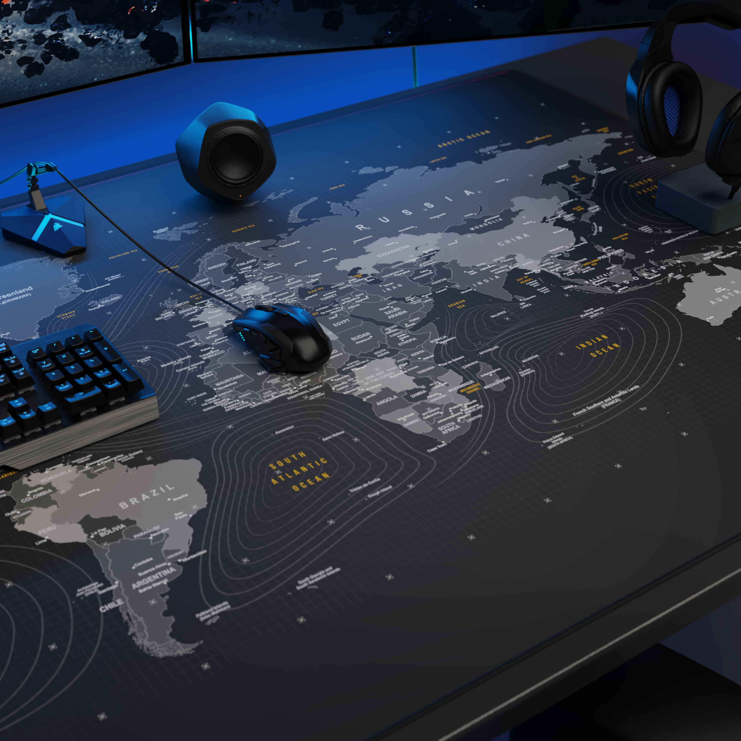Ein Gaming-Schreibtisch mit einer großen Weltkarten-Mausmatte, einer Tastatur, Maus, Lautsprechern und Kopfhörern.