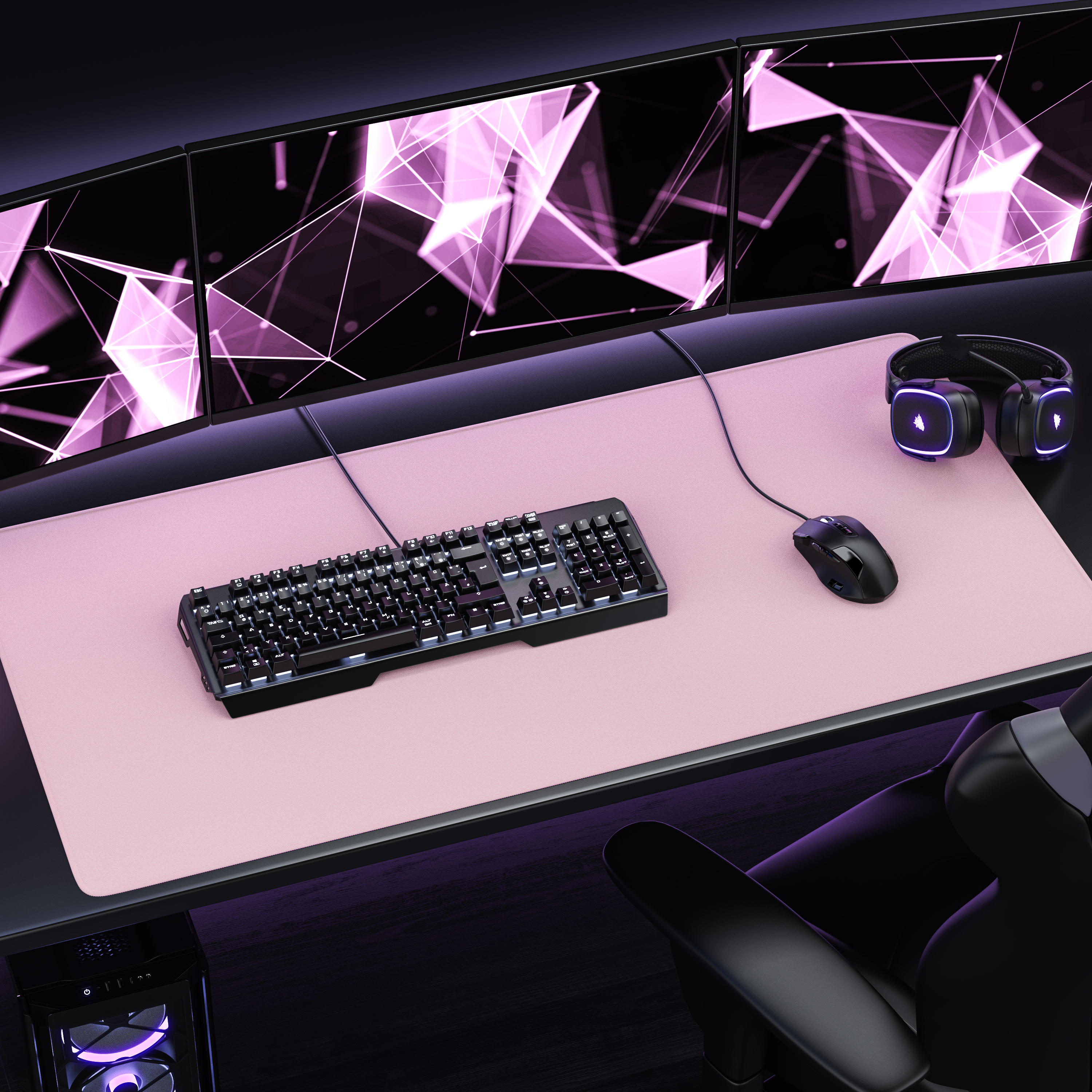 Ein Gaming-Schreibtisch mit drei Monitoren, Tastatur, Maus, Headset und einem großen rosa Mauspad.