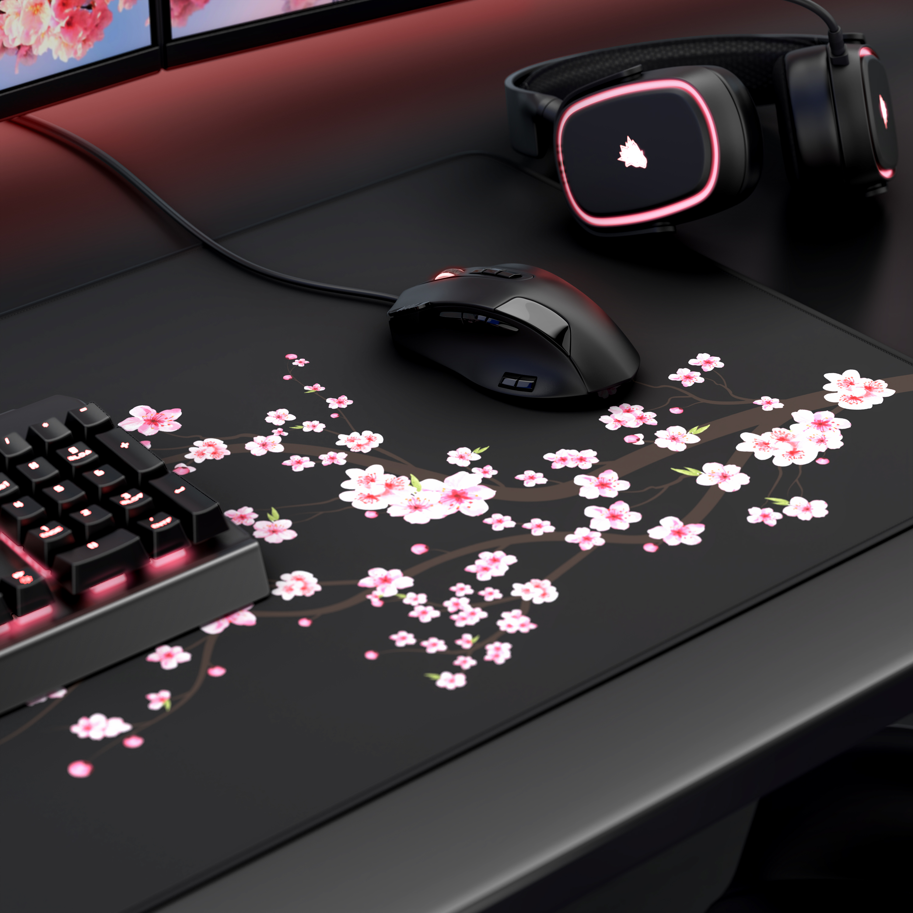 Schwarzes Gaming-Setup mit Maus, Tastatur und Kopfhörern auf einem Schreibtisch mit Kirschblütenmotiv.