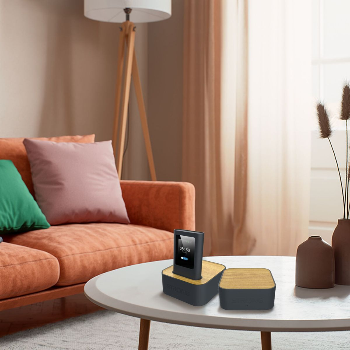 Salón con sofá naranja y dispositivos negros con tapa de madera en una mesa blanca.