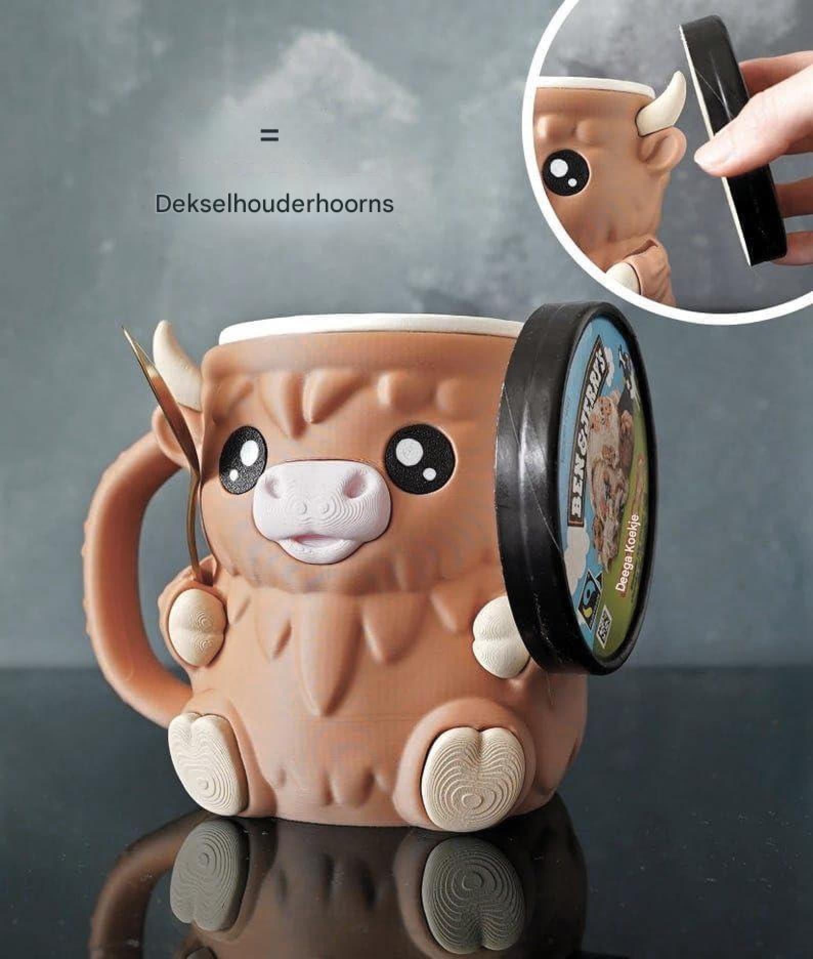 Braune Tasse in Tierform mit großen Augen und Hörnchen als Deckelhalter.
