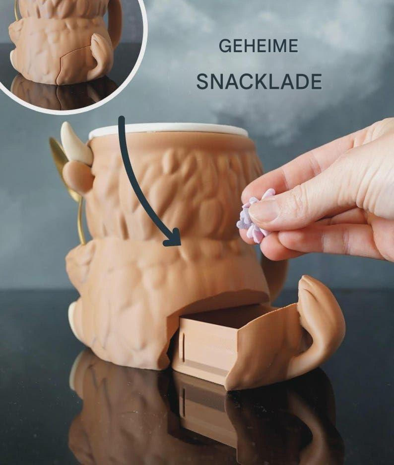 Eine Hand legt einen Snack in die geheime Schublade eines braunen Hochlandrind-Bechers.
