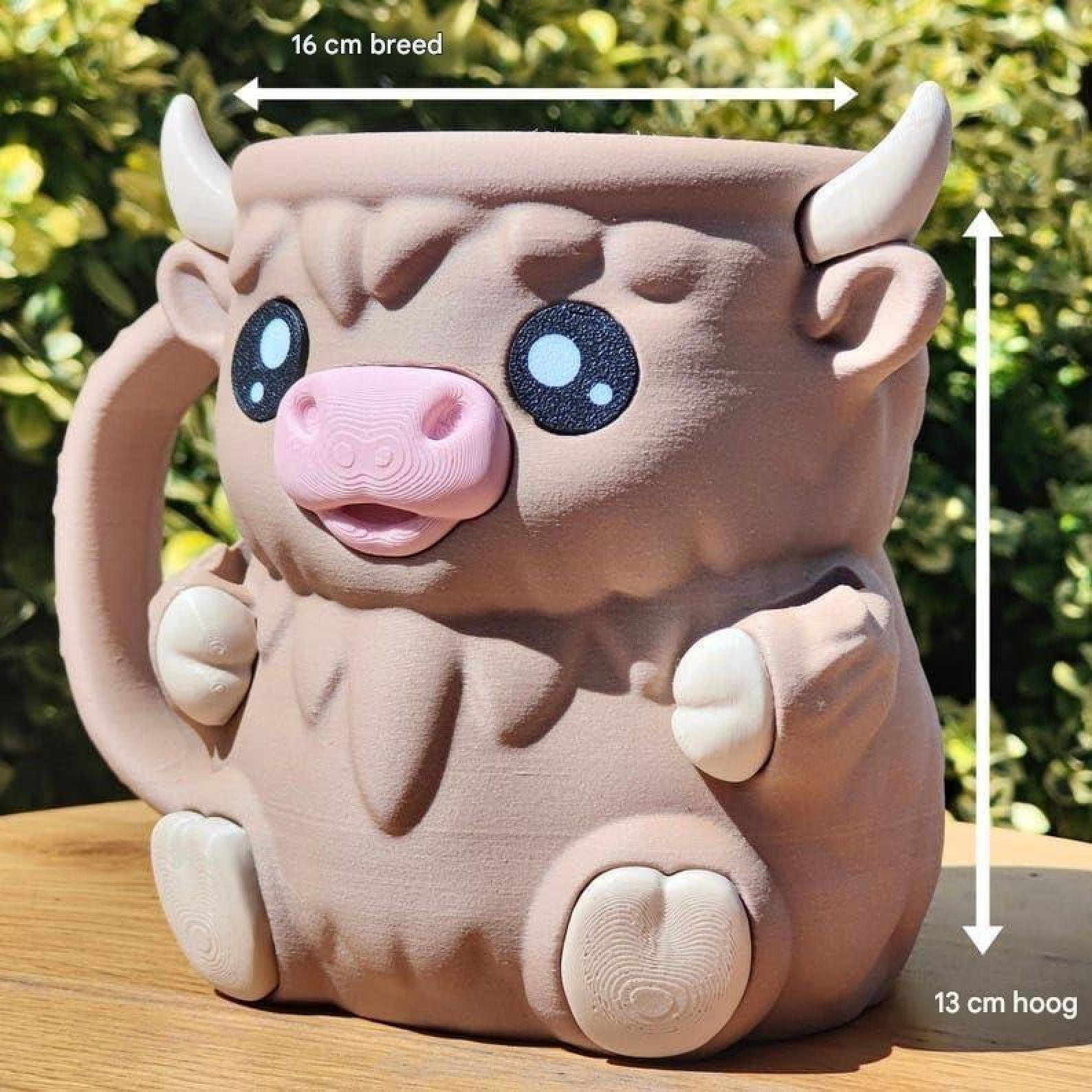 Eine braune, niedliche Kuh-Tasse mit rosa Schnauze, Hörnern und Maßangaben auf einem Holztisch.