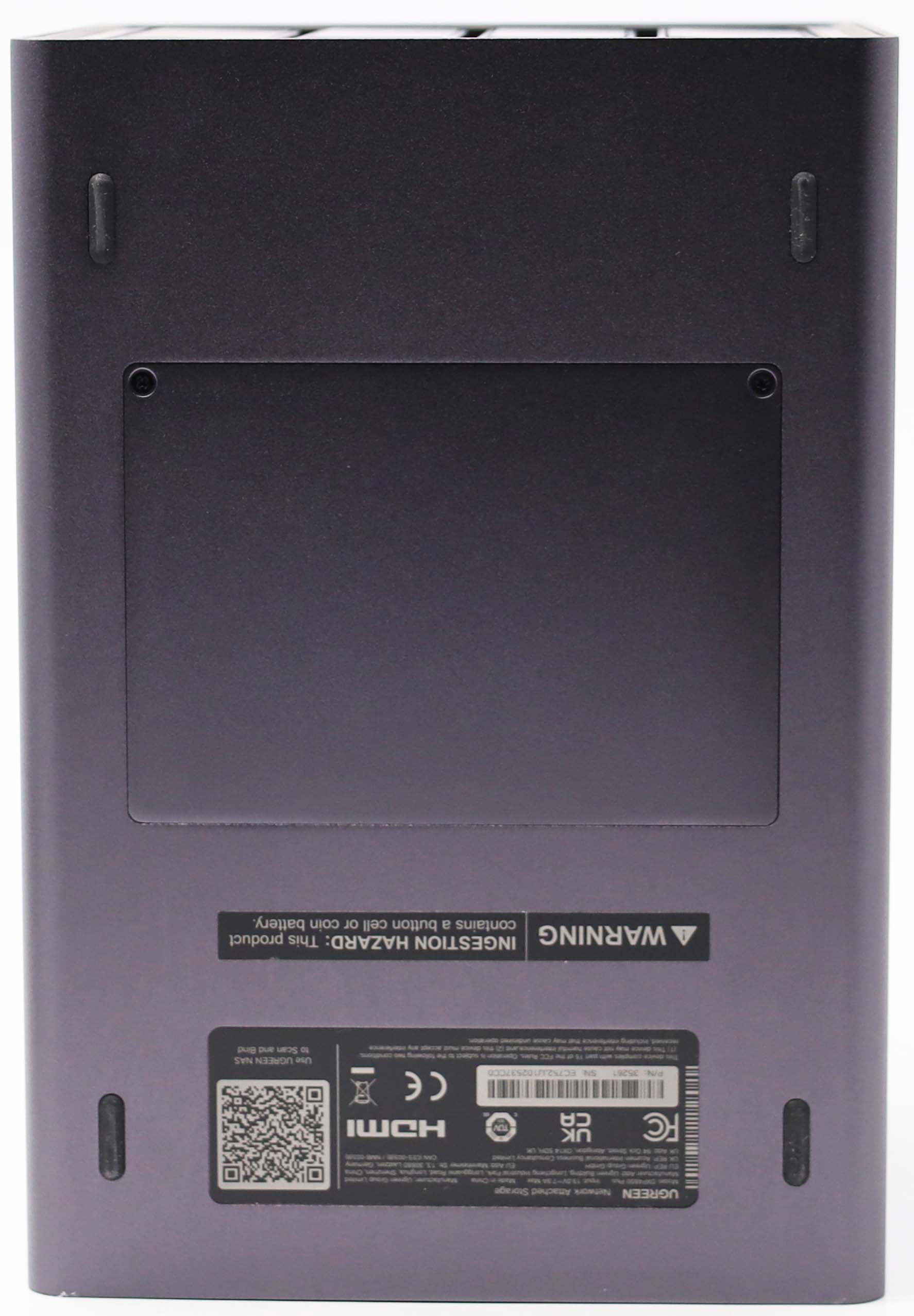 Unterseite eines schwarzen Ugreen NAS mit Gummifüßen, Batteriefach, CE- und FCC-Zeichen sowie QR-Code.