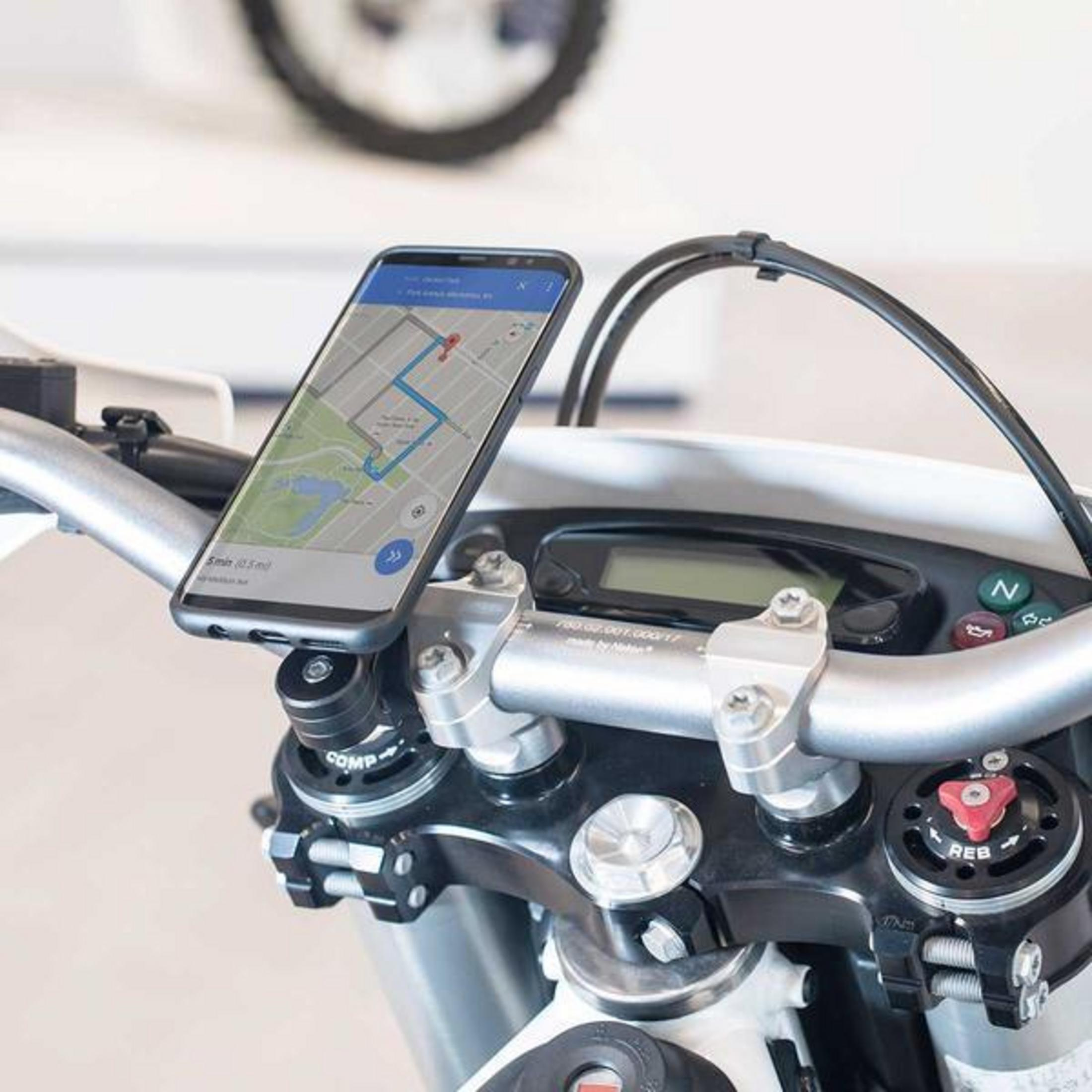 Ein Smartphone mit einer Navigations-App ist am Lenker eines Motorrads befestigt.