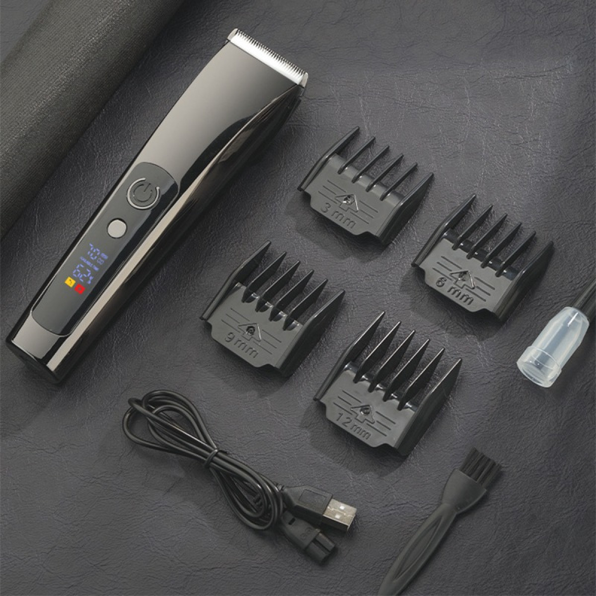 Ein schwarzer Haarschneider mit vier Aufsätzen, Ladekabel, Reinigungsbürste und Öl auf dunklem Untergrund.