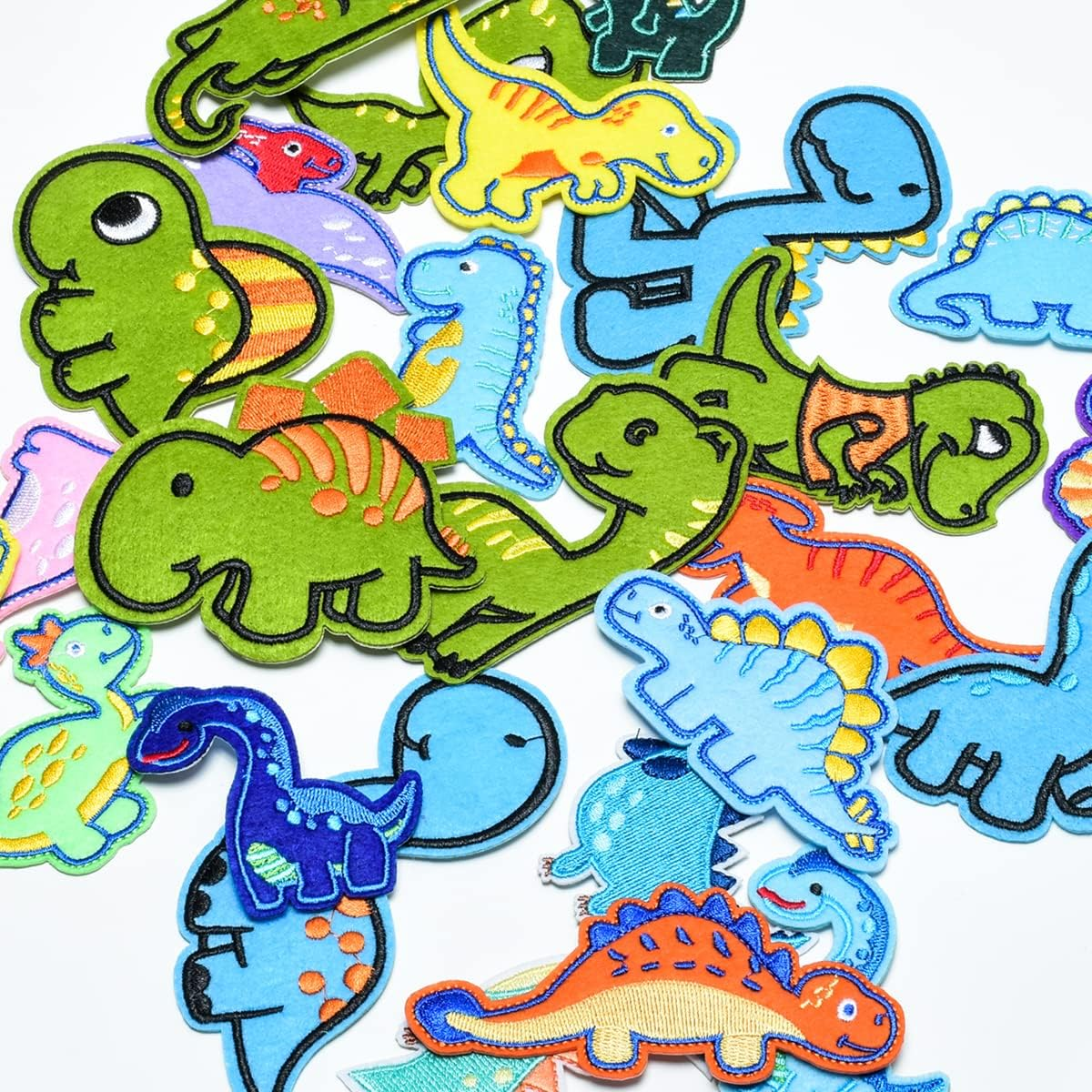 Eine bunte Sammlung verschiedener Filz-Dinosaurier-Aufnäher auf weißem Hintergrund.