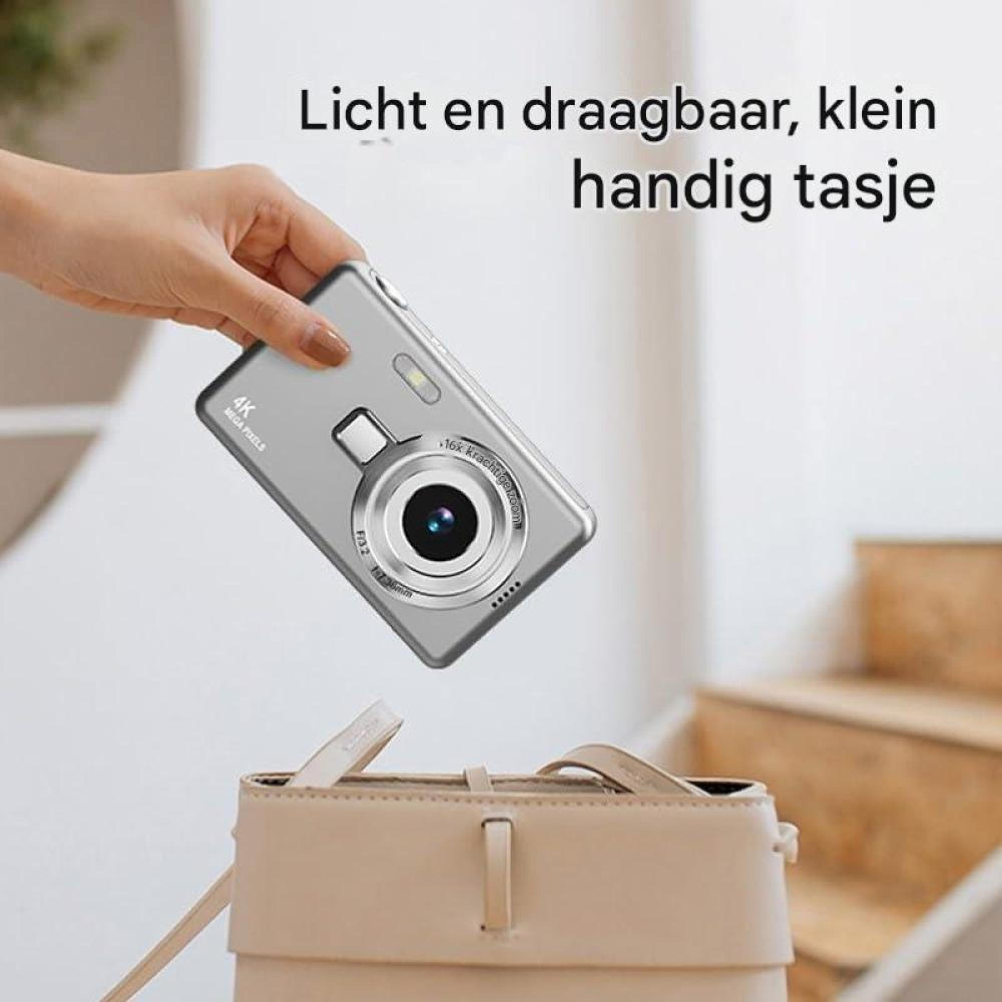 Eine Hand hält eine kleine silberne Digitalkamera über eine beigefarbene Tasche. Holländischer Text im Hintergrund.