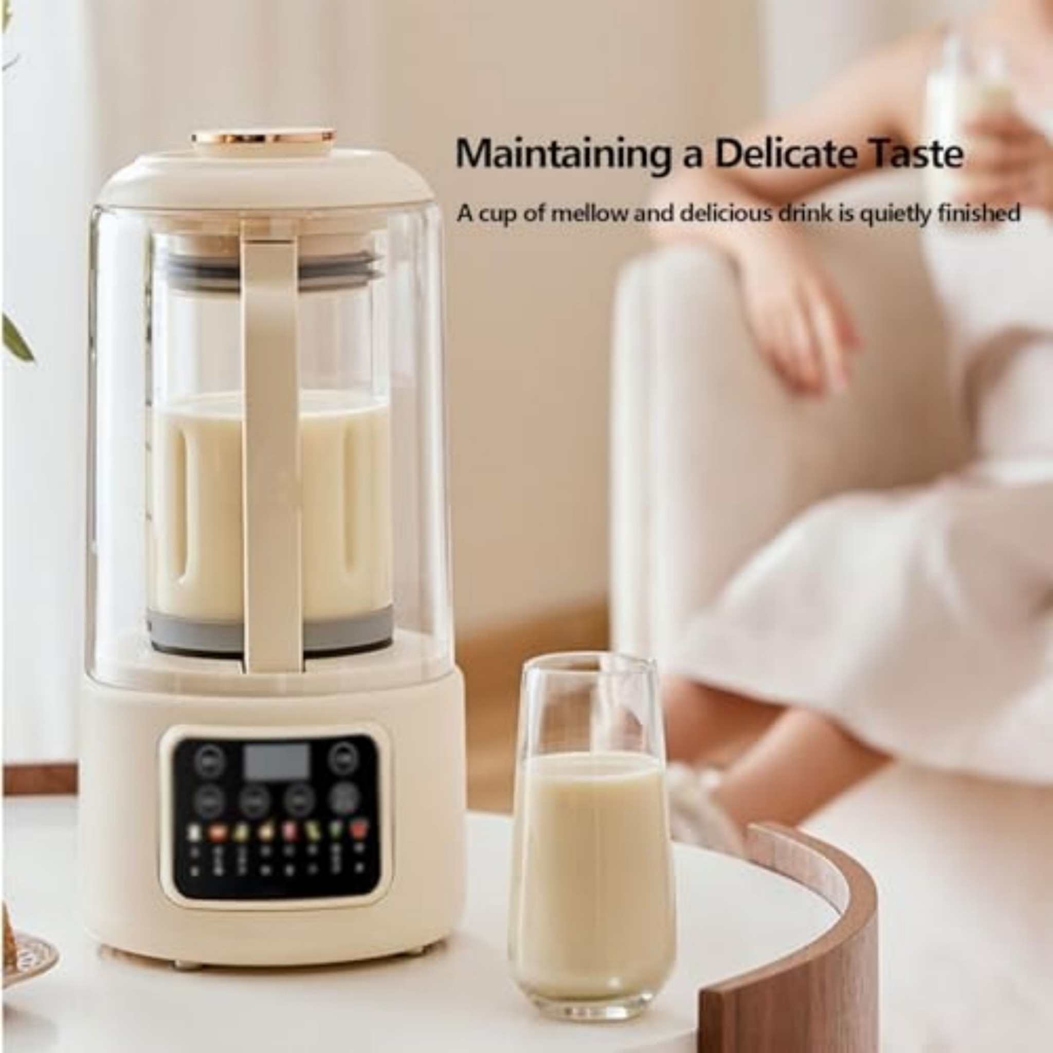 Beige Kaffeemaschine auf weißem Tisch mit Glas und verschwommener Person im Hintergrund.