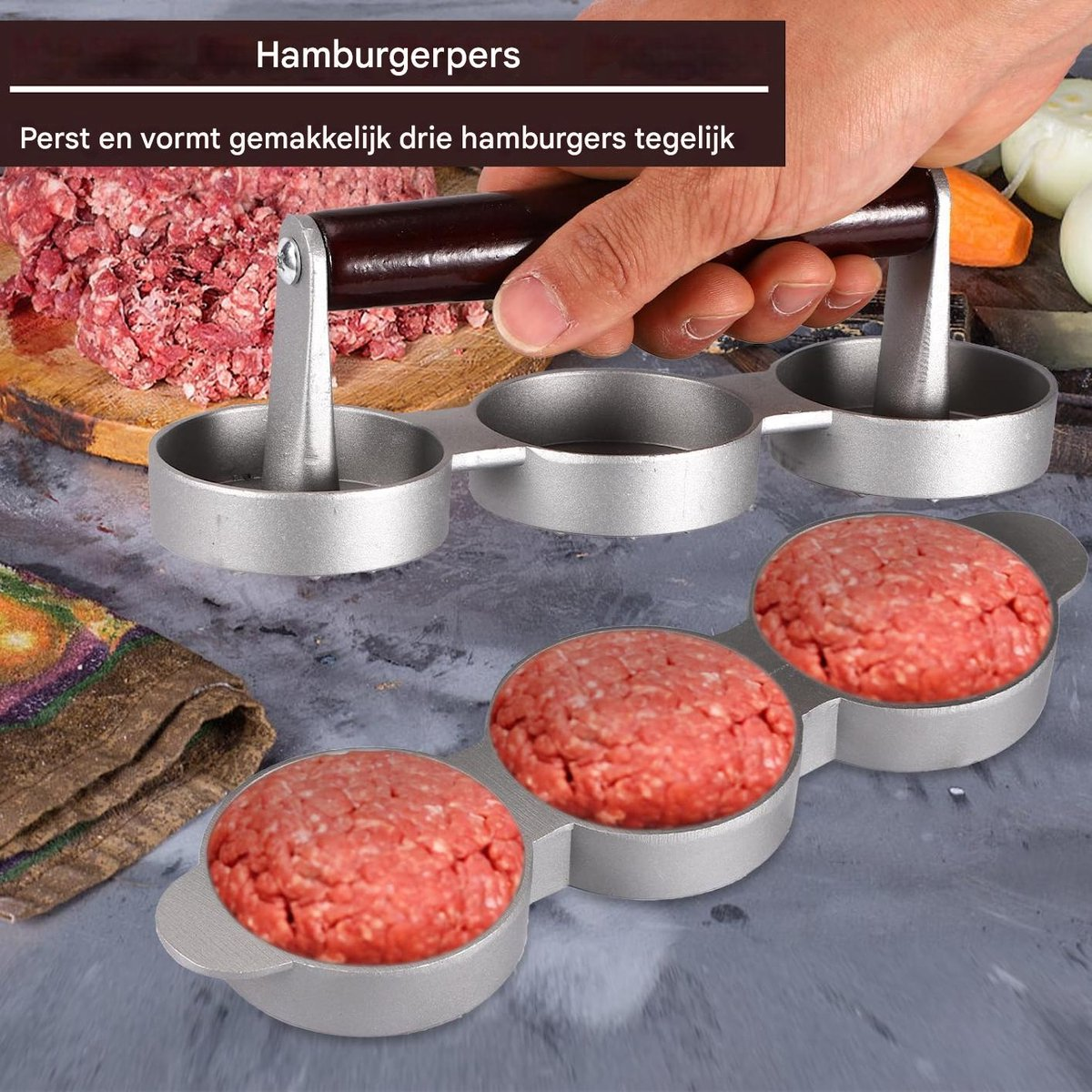 Eine Hand benutzt eine silberne Burgerpresse für drei Patties, gefüllt mit rohem Hackfleisch auf einem Tisch.