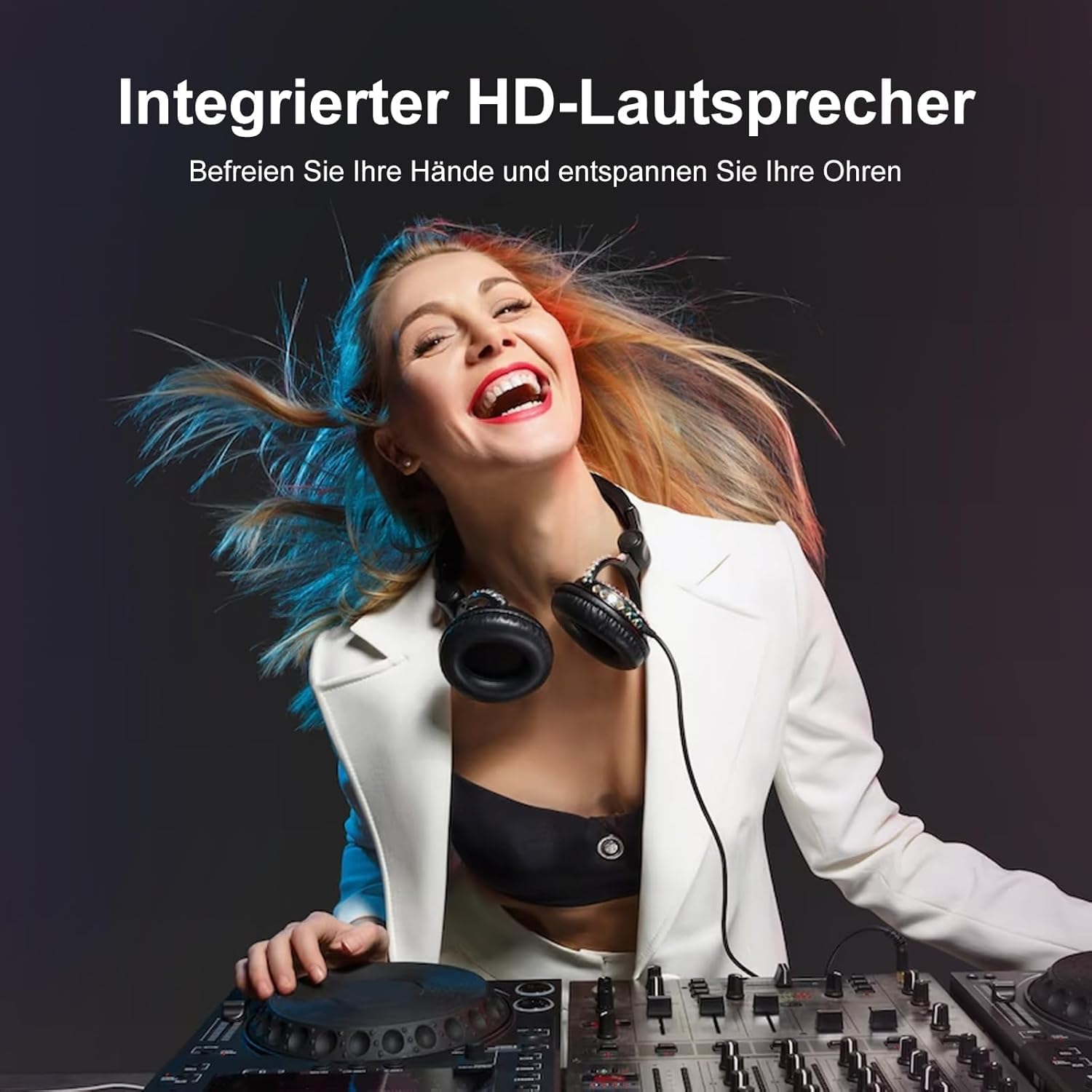 Eine blonde Frau lacht, trägt eine weiße Jacke und Kopfhörer, während sie an einem DJ-Mischpult steht.