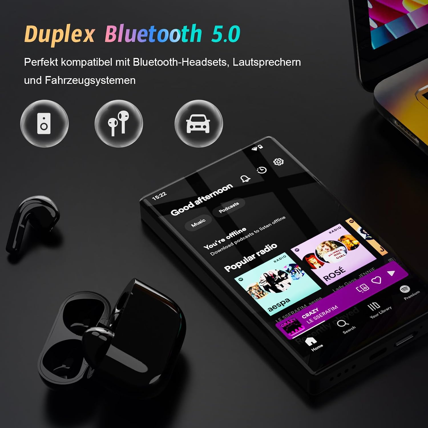 Ein Smartphone mit Musik-App liegt neben schwarzen kabellosen Ohrhörern auf einer dunklen Oberfläche.