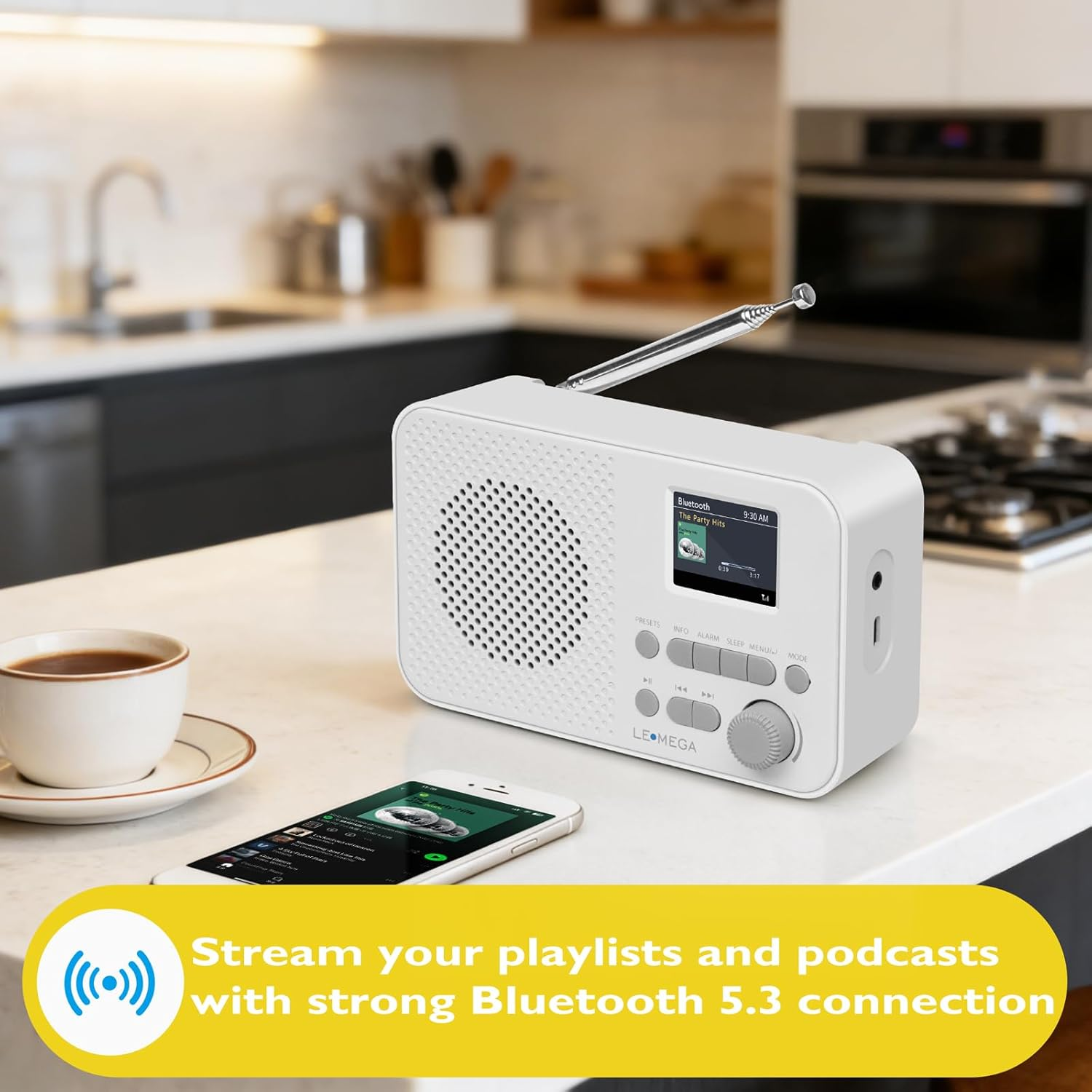 Weißes Radio und Smartphone auf der Küchentheke mit einer Tasse Kaffee.