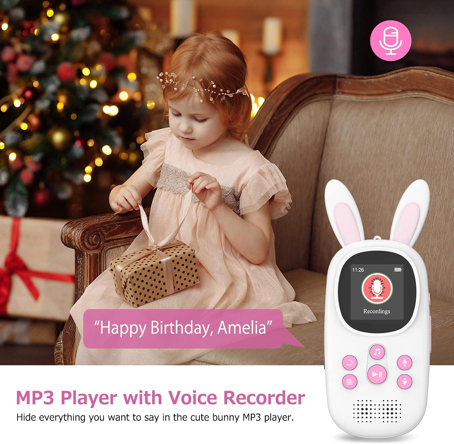 Ein kleines Mädchen im rosafarbenen Kleid öffnet ein Geschenk neben einem Hasen-MP3-Player.