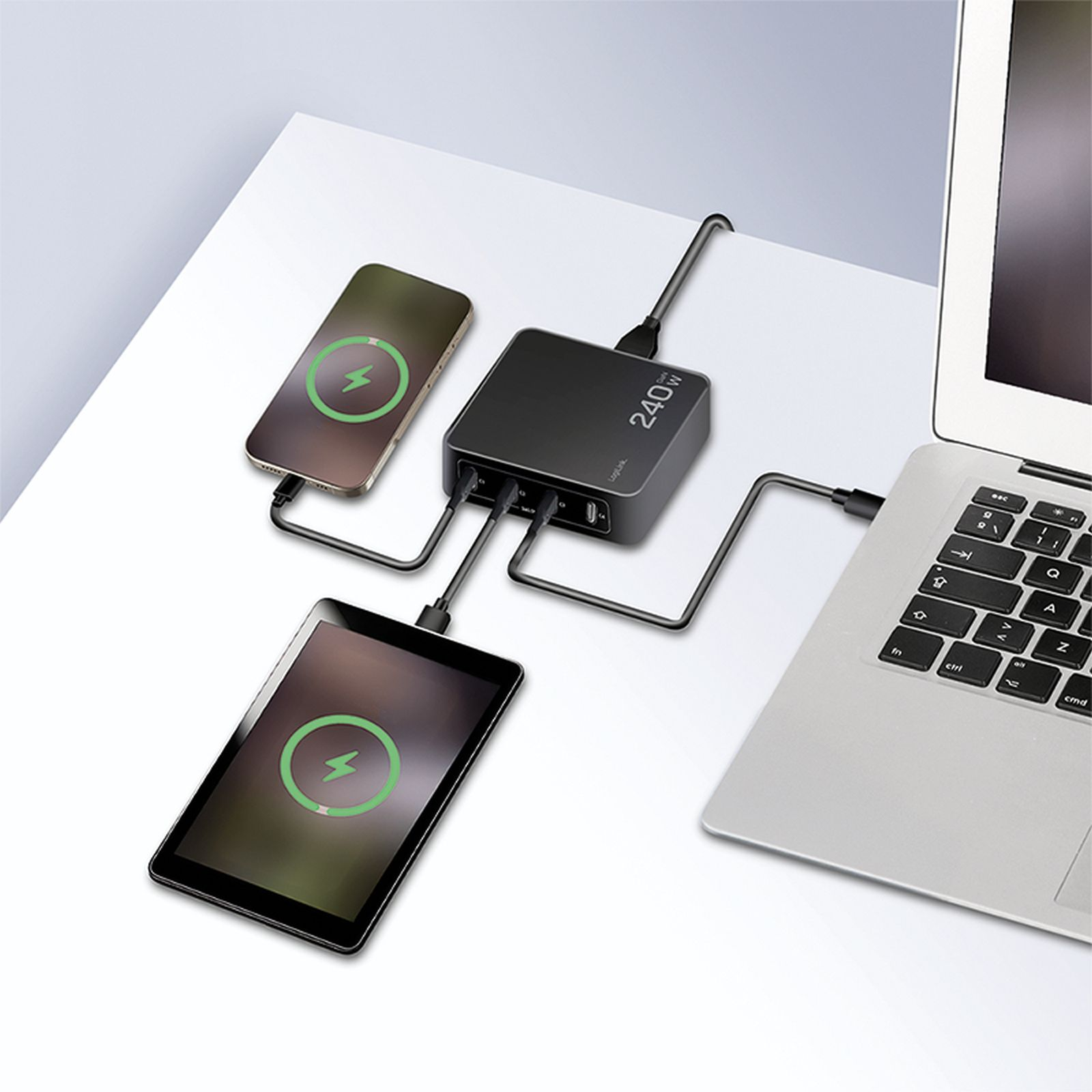 Eine schwarze 240W Ladestation verbindet ein Smartphone, ein Tablet und einen Laptop auf einem weißen Tisch.