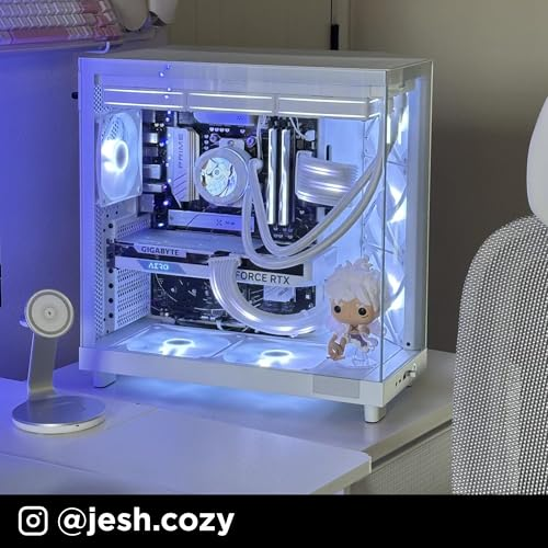 Une tour de PC blanche avec éclairage bleu, refroidissement liquide et une petite figurine à l'intérieur, sur un bureau.